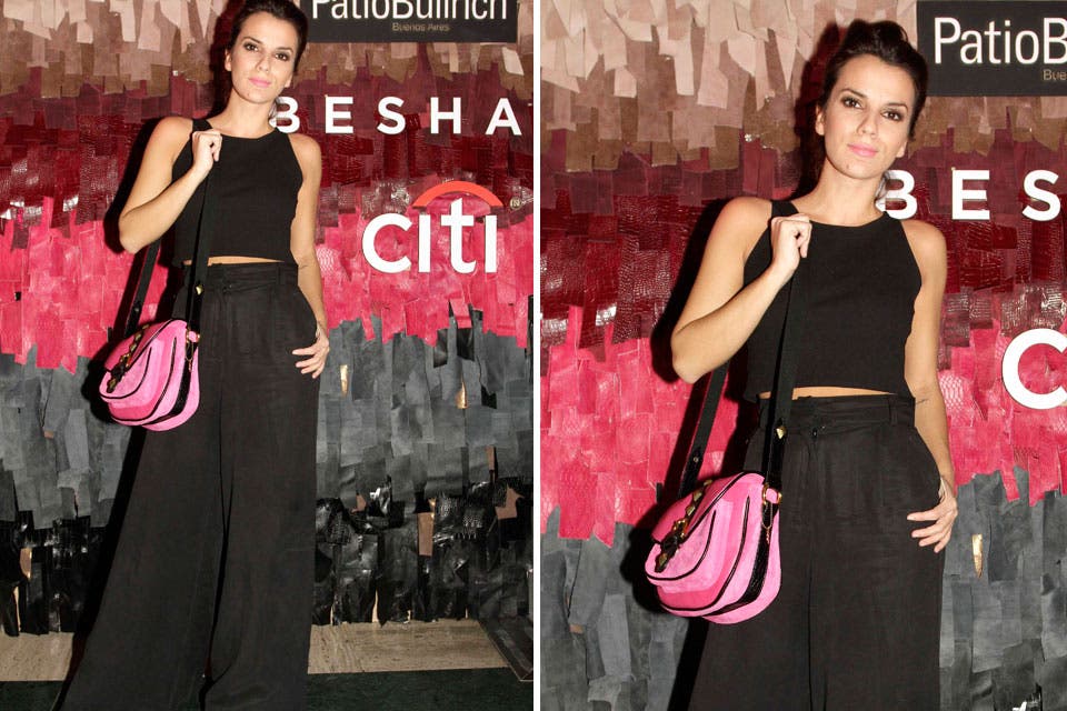 Gimena Accardi con crop top y palazzo a la cintura. Para sumar un poco de color a su equipo sumó una cartera en rosa chicle con detalles en negro