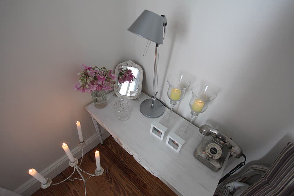 La mesa de luz es una suma de objetos que aportan calidez: flores, velas, un espejo restaurado, mini portarretratos y un teléfono antiguo que se integra a la perfección. El piso de pinotea fue pulido e hidrolaqueado