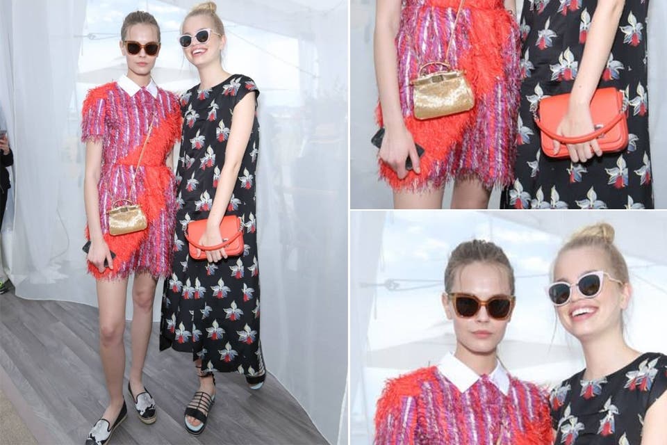 Mina C y Daphne Groeneveld, dos modelos en composé: Daphne con un vestido largo de satén con un estampado de orquídeas y Mina con un minidress de plumas en fucsia y rojo