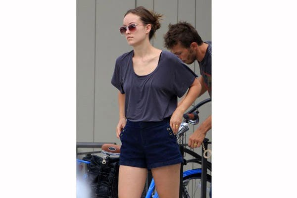 Olivia Wilde, con short azul de tiro alto y remera holgada