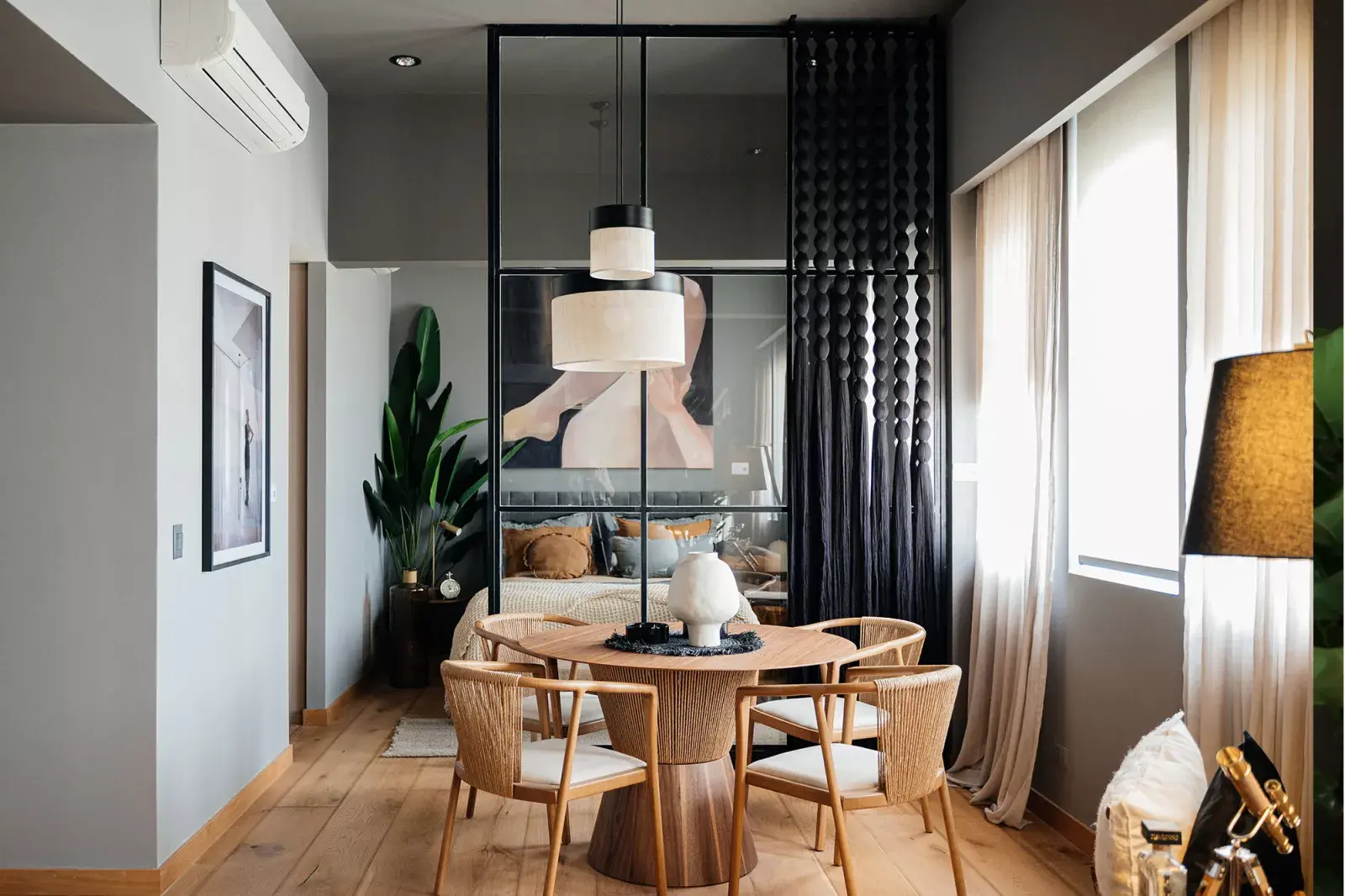 Mix de tendencias en el espacio de Gaby Orlando: comedor circular, divisor que deja ver más allá y un dormitorio protagonista con textiles, arte y verde natural