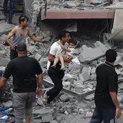Un palestino lleva a un niño rescatado de la casa de la familia Tattari, que fue destruida en un ataque aéreo israelí en la ciudad de Gaza el 9 de octubre de 2023. Entre los muertos hay 4 argentinos; al menos otros 4 están desaparecidos.