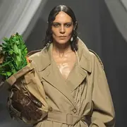 La modelo lució sobre la pasarela un trench por debajo de la rodilla en color camel y un collar de perlas