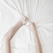 Un par de manos aferradas con fuerza a las sábanas.