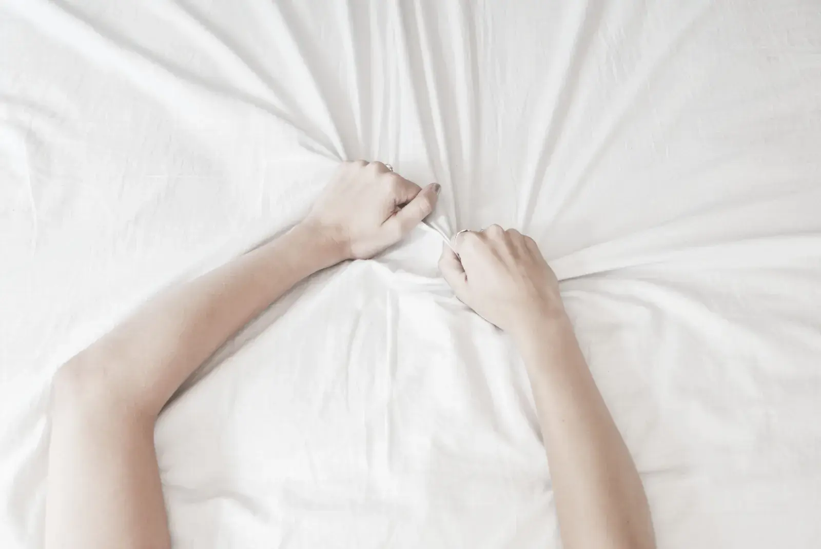 Un par de manos aferradas con fuerza a las sábanas.