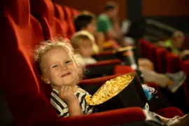 Nena comiendo pochoclos en el cine