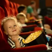 Nena comiendo pochoclos en el cine