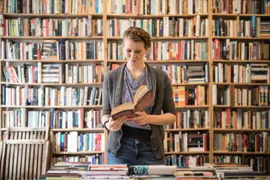 mujer leyendo un libro en una librería.