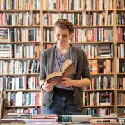 mujer leyendo un libro en una librería.