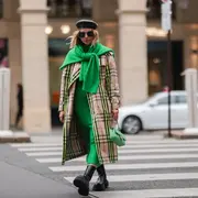 Mujer caminando con trench por la calle.