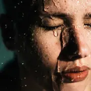 Mujer con el rostro salpicado de agua.