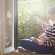 Mujer embarazada escuchando un pódcast.