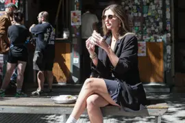 Chica comiendo en la calle en Chacarita