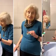 Una mujer maquillándose en el espejo de su casa