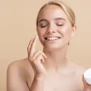 Foto de una mujer poniéndose crema hidratante en el rostro.