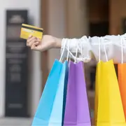 Una mujer con bolsas de colores en la mano