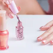 Una mujer pintándose las uñas