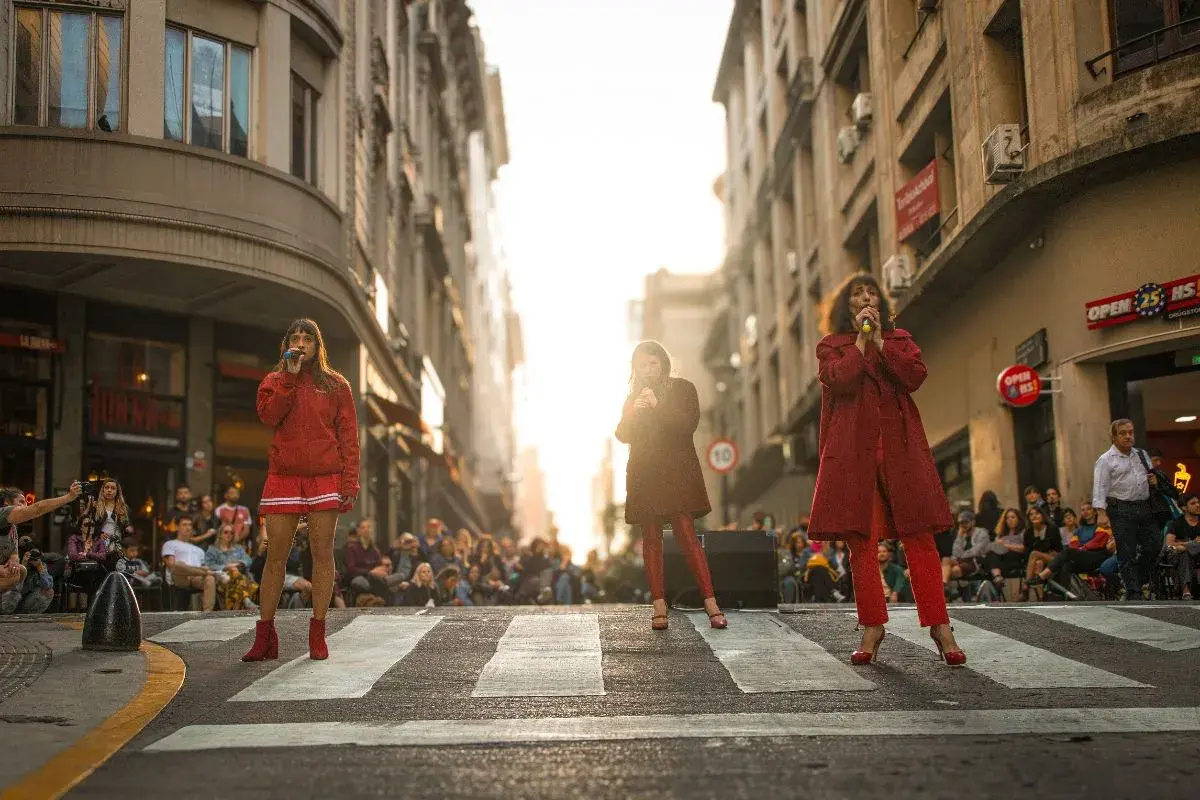 Mujeres vestidas de rojo en la ciudad haciendo una performance en la calle.
