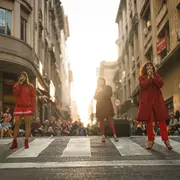 Mujeres vestidas de rojo en la ciudad haciendo una performance en la calle.