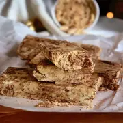 Pilas de trozos de mantecol con chocoalte sobre un plato y papel manteca