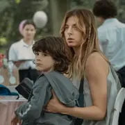 Una mamá sosteniendo a un niño a upa.