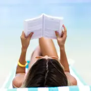 Una mujer leyendo en la playa