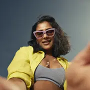 Una mujer con anteojos con una campera en color amarillo