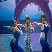 Tres mujeres cantando en un escenario.