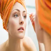 Una mujer depilándose las cejas