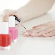 Una mujer pintándose las uñas