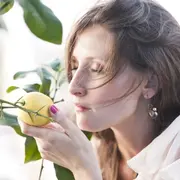 mujer oliendo un limón