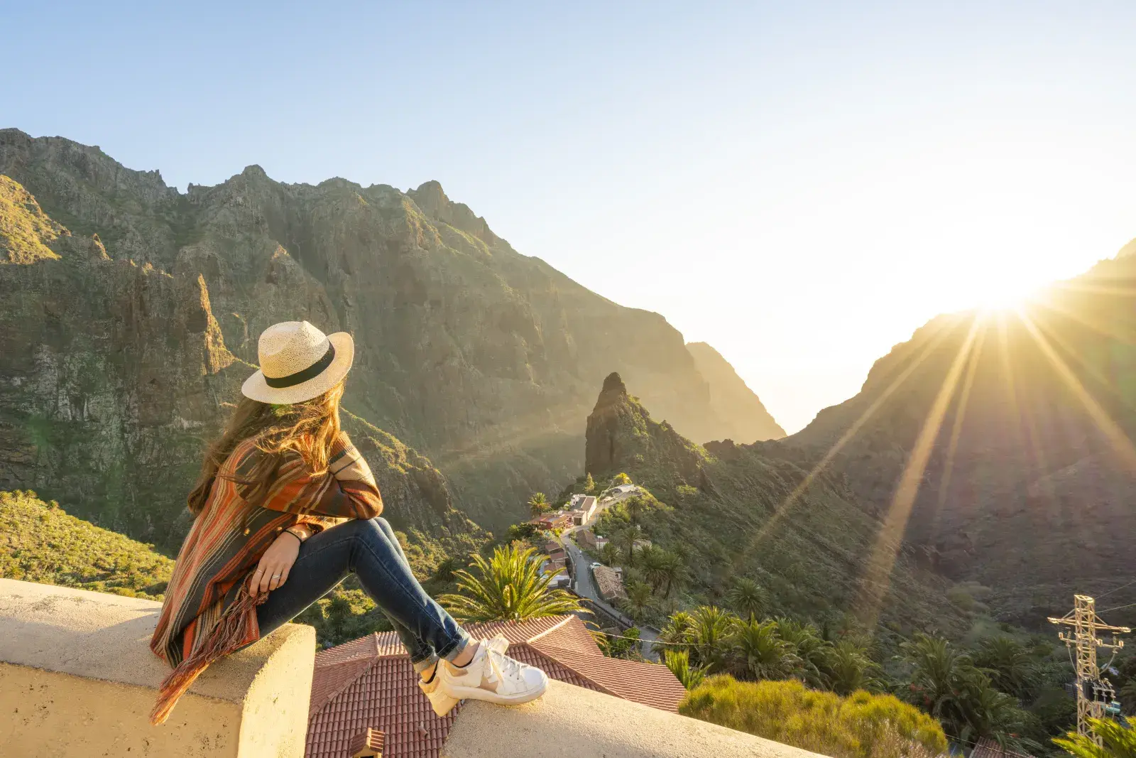 Una mujer mirando un paisaje montañoso.