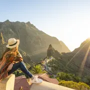 Una mujer mirando un paisaje montañoso.