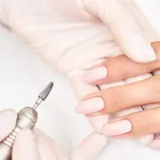 Una mujer pintándose las uñas