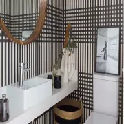 Un toque súper arty con un recurso que abre muchísimas posibilidades: el toilette va empapelado. 