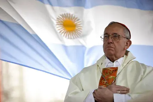 El cardenal argentino Jorge Bergoglio oficia una misa ante la iglesia de San Cayetano, con una bandera argentina detrás, en Buenos Aires, Argentina, el viernes 7 de agosto de 2009. (AP Foto/Natacha Pisarenko, archivo)