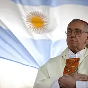 El cardenal argentino Jorge Bergoglio oficia una misa ante la iglesia de San Cayetano, con una bandera argentina detrás, en Buenos Aires, Argentina, el viernes 7 de agosto de 2009. (AP Foto/Natacha Pisarenko, archivo)