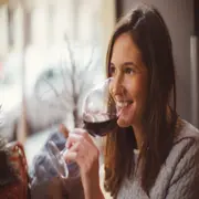 mujer toma vino tinto
