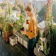 Foto de mujer cuidando sus plantas.