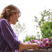 Foto de mujer cuidando sus plantas.