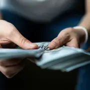 Foto de mujer ordenando billetes.