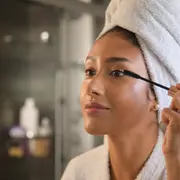 Foto de mujer peinandose las pestañas.