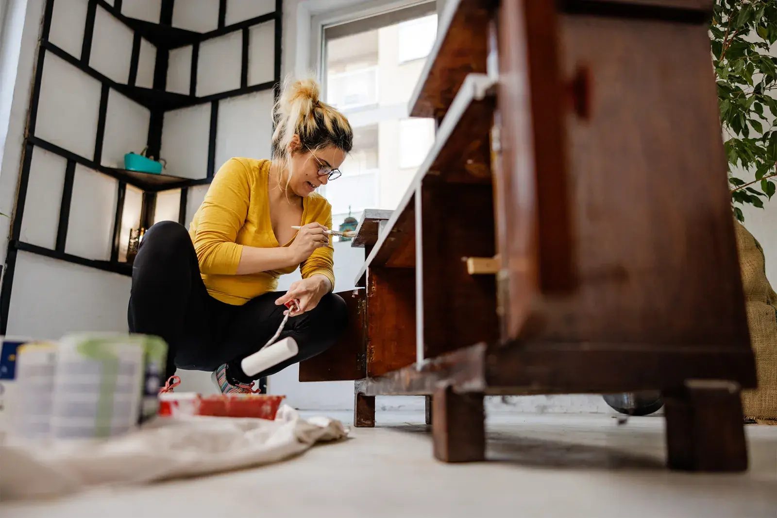 Foto de mujer reparando un mueble antiguo.