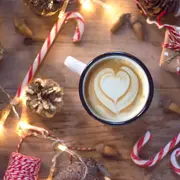 Una taza de café sobre una mesa decorada para Navidad
