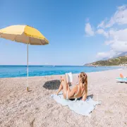 mujer leyendo en la playa