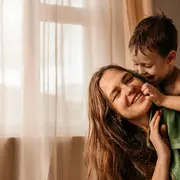 Foto de mujer jugando con su hijo.
