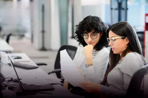 Dos mujeres analizando papeles. Dos mujeres analizando papeles.