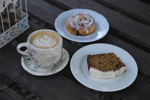 Una mesa con un café, un budín y un roll de canela. Una mesa con un café, un budín y un roll de canela.
