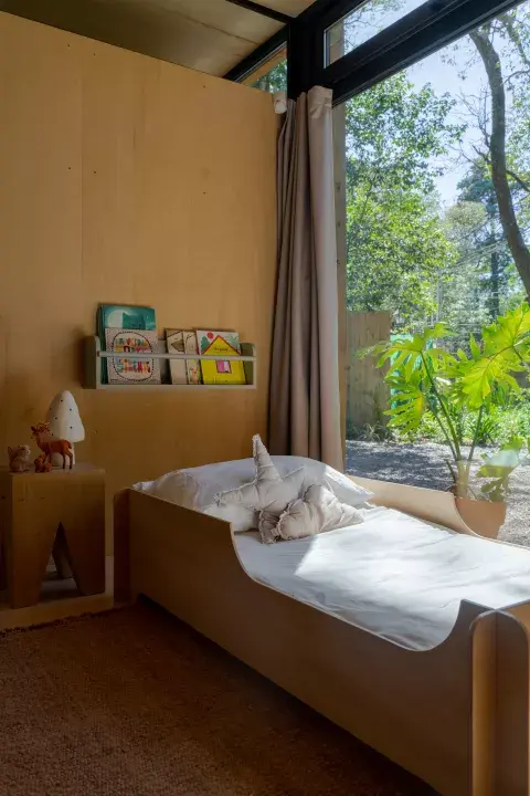 El dormitorio es uno solo y ahí duermen los tres; al costado de la cama de sus papás, Blanca tiene su camita y rincón de lectura. Todos los muebles y el revestimiento de pisos, paredes y cielorraso de la casa los realizó Pablo Russo. Los textiles son de Casa Bulla (@casabulla).