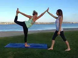 Clase de yoga al aire libre frente al río.